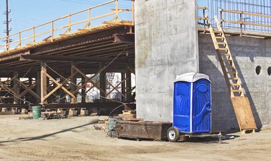 row of portable toilets on a busy construction site